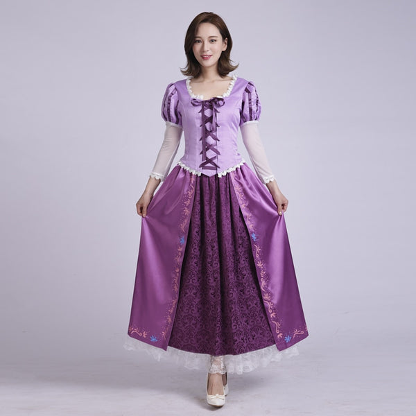 A woman standing and posing in a purple satin Rapunzel cosplay costume with white lace and blue accents.